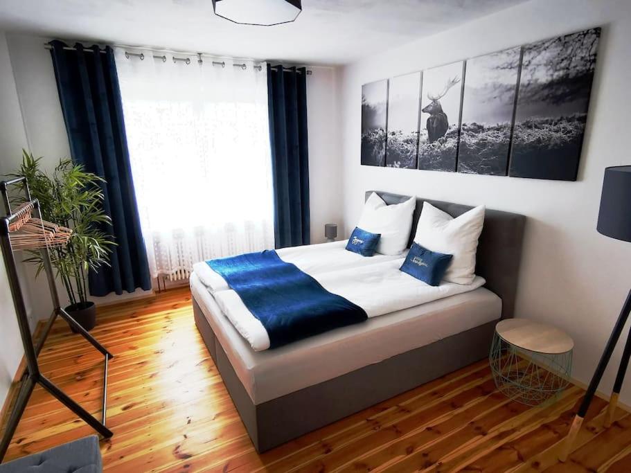 a bedroom with a bed with blue and white pillows at Auszeit im Seenland in Hohenbocka