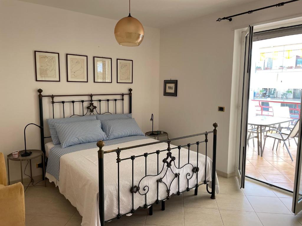 a bedroom with a bed and a balcony with a table at Casa Giacobelli in Mola di Bari