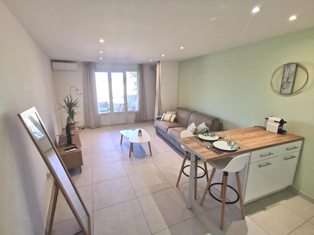 un salon avec un canapé et une table dans l'établissement Superbe appartement avec piscine et stationnement, à Sainte-Maxime
