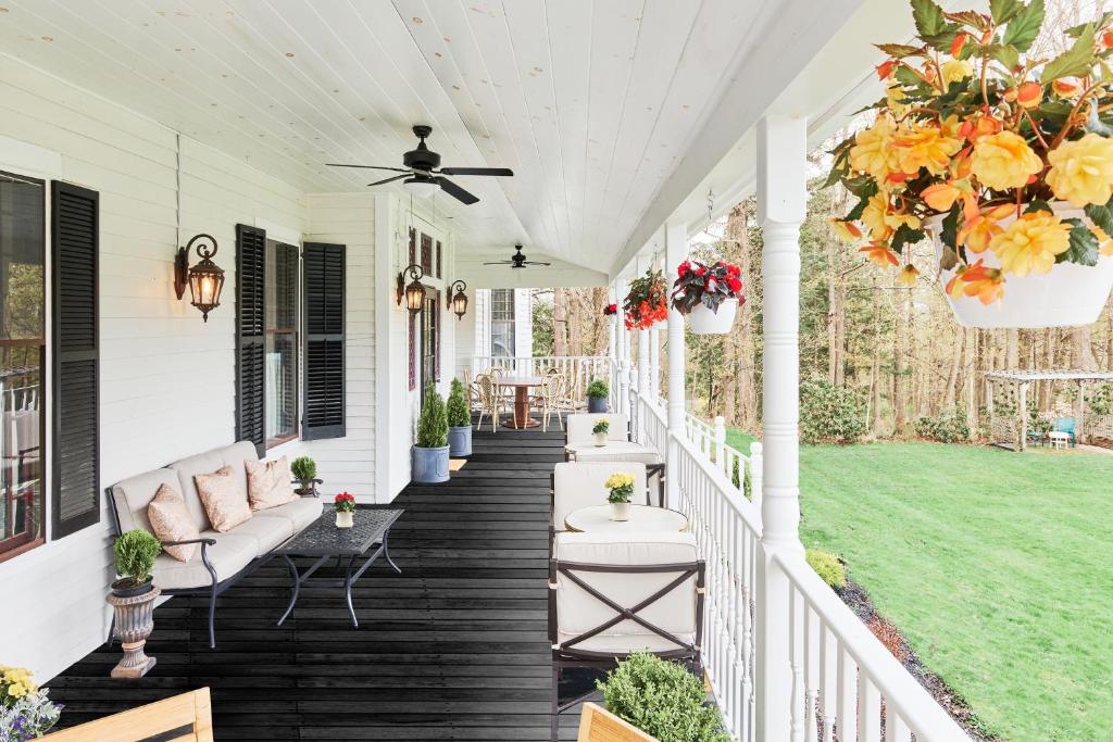 a porch with a couch and flowers on it at The Lenox Collection in Lenox