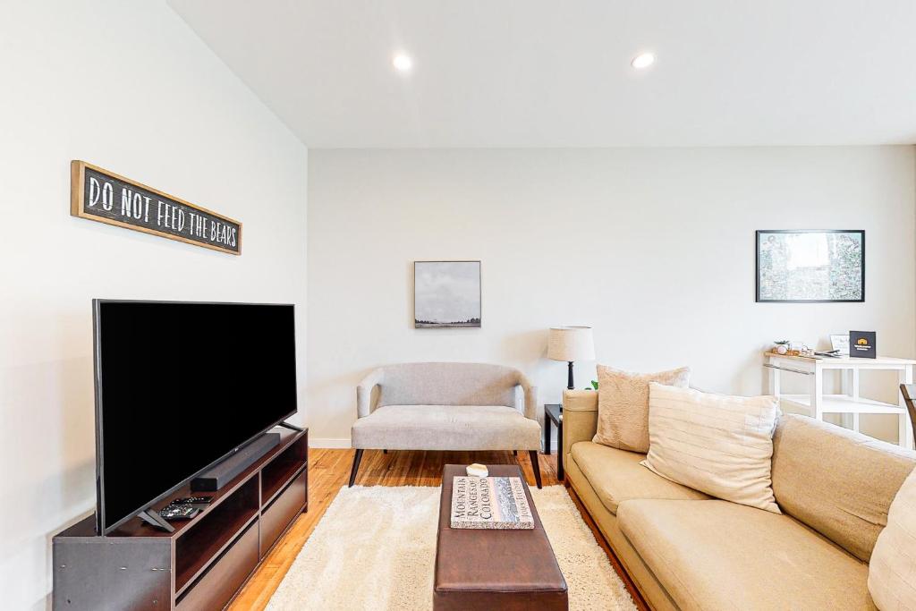 sala de estar con sofá y TV de pantalla plana en Modern Gem in Gypsum en Eagle