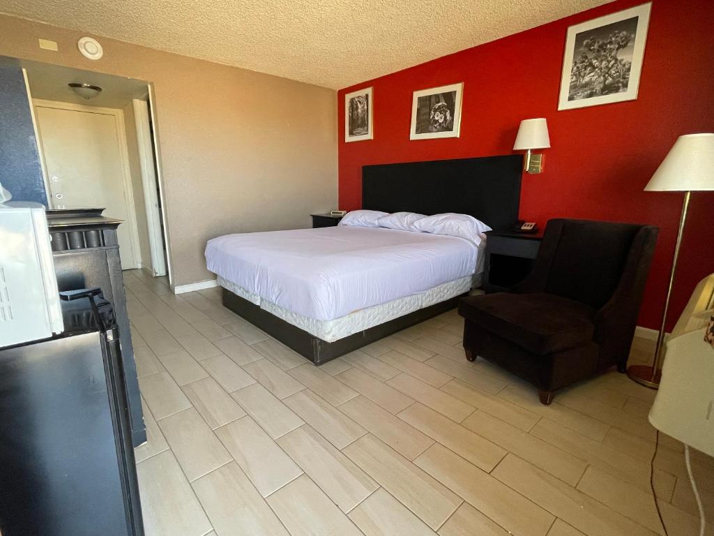 a hotel room with a bed and a chair at Travelodge by Wyndham Imperial - El Centro in El Centro