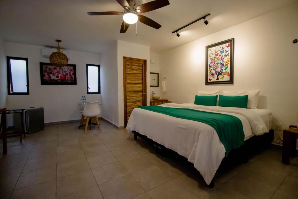 een slaapkamer met een groot bed en een plafondventilator bij Hotel Tequila Cancun in Cancun