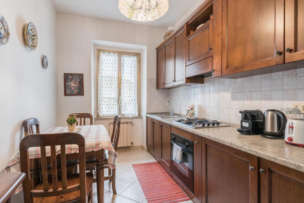 una cucina con armadi in legno e un tavolo con sala da pranzo di Warm apt in ancient building in Vatican-P S Pietro a Roma