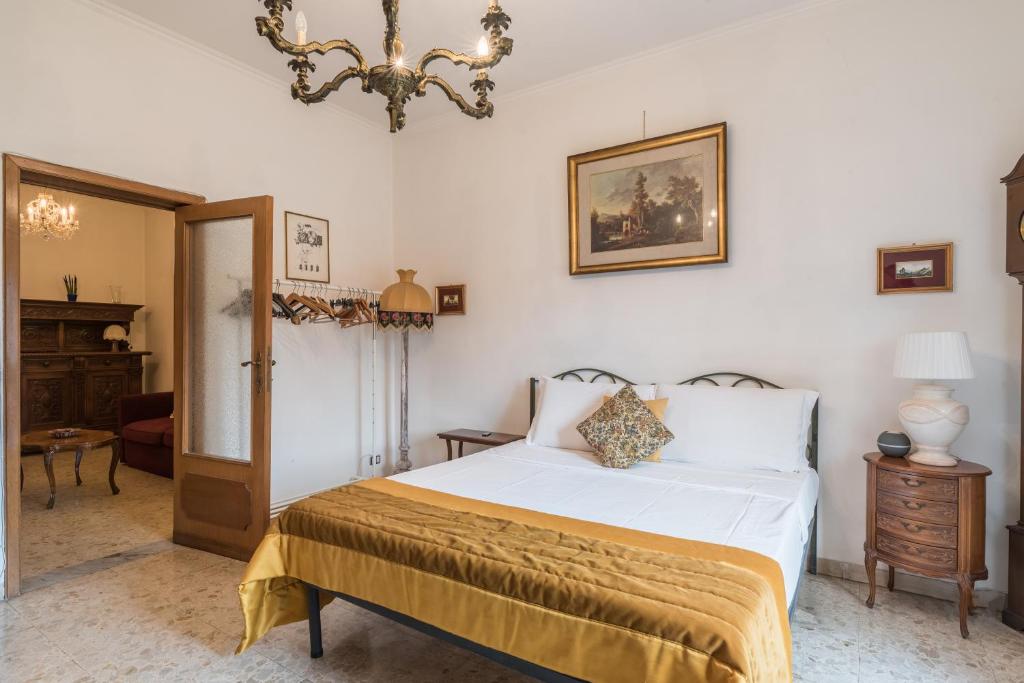 una camera da letto con un letto e un lampadario di Warm apt in ancient building in Vatican-P S Pietro a Roma