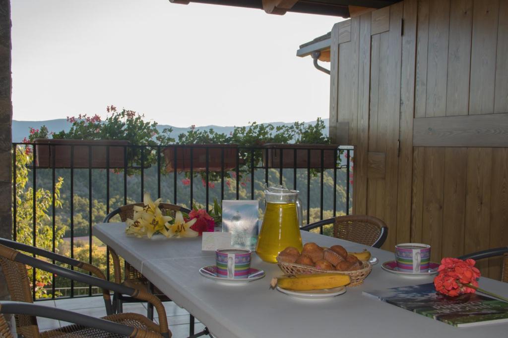 El Pueyo de AraguásにあるCasa Rural Pueyoのバルコニーにテーブル(フルーツ、ジュース付)