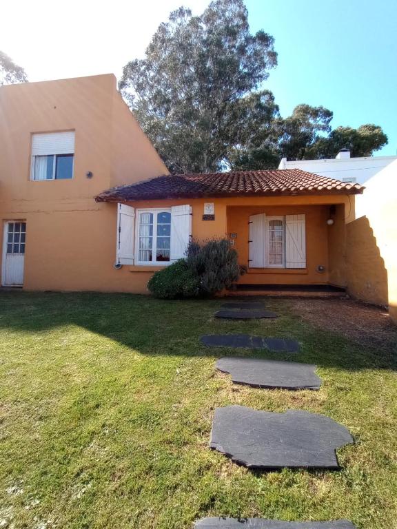 a house with a grass yard in front of it at Alquileres Viviana in Tandil