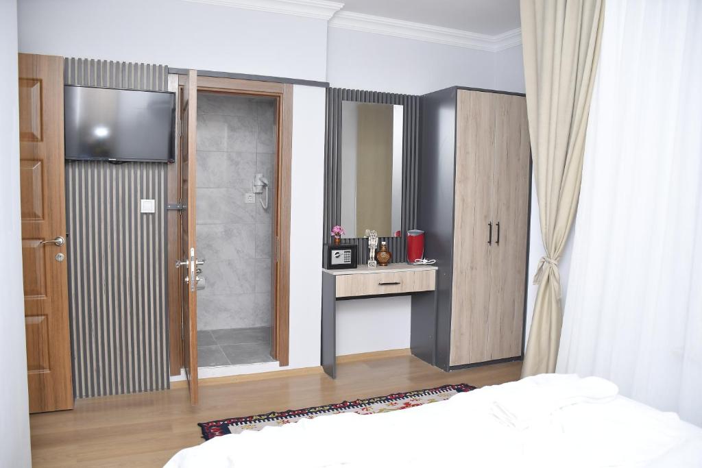 a bedroom with a bed and a shower and a mirror at Hotel Arinna in Istanbul