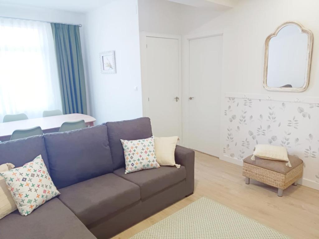 salon z niebieską kanapą i lustrem w obiekcie A Capelada-Céntrico apartamento en Cedeira w mieście Cedeira