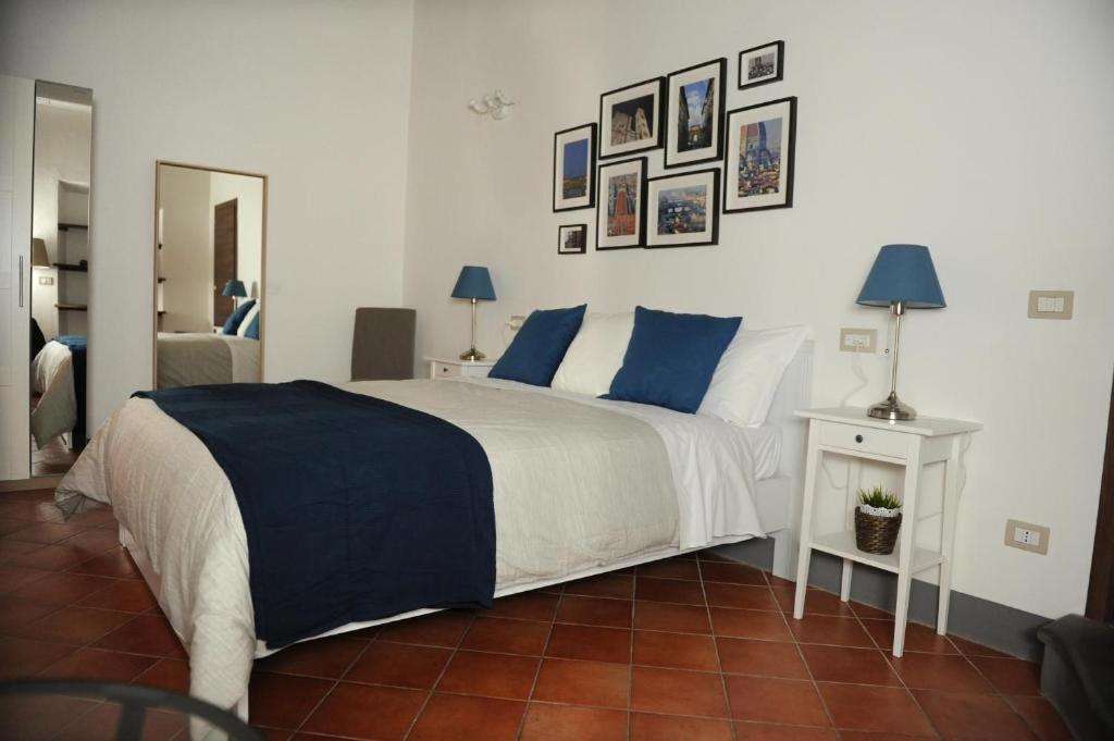 a bedroom with a large white bed with blue pillows at Condotta3Rooms in Florence