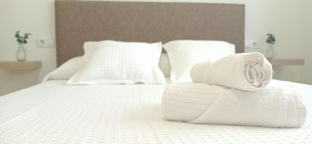 stos ręczników na białym łóżku w obiekcie A Capelada-Céntrico apartamento en Cedeira w mieście Cedeira