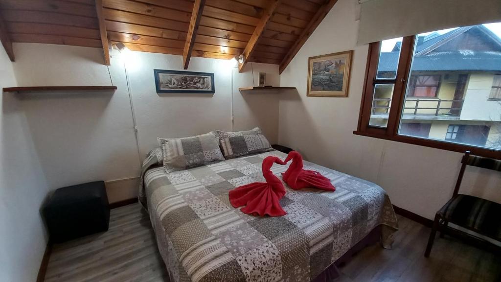 a bedroom with a bed with a red ribbon on it at Cabaña turística Weber in San Martín de los Andes