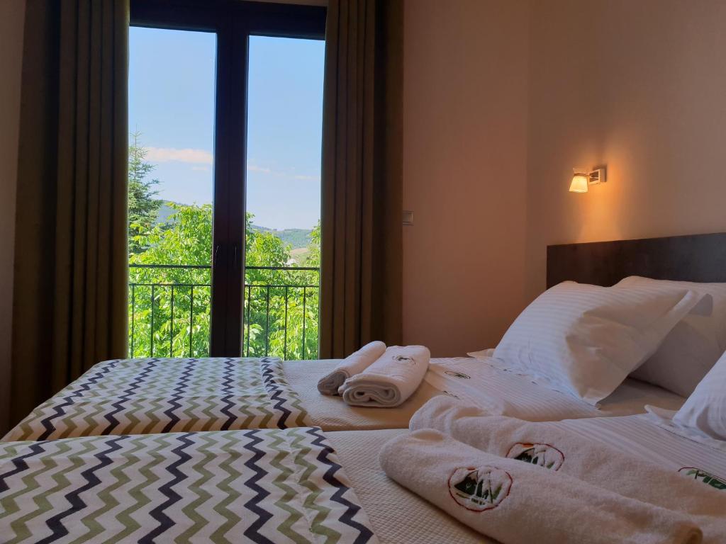 a bedroom with two towels on a bed with a window at Mondeus Inn Luxury 
