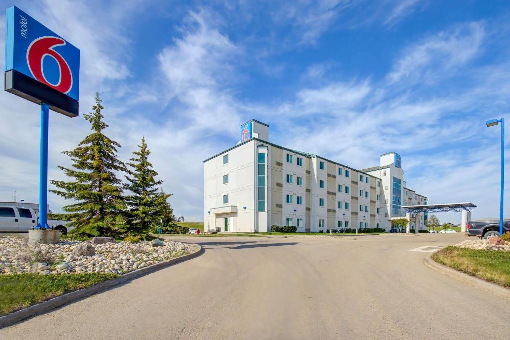 a large white building with a sign in front of it at Motel 6-Grande Prairie, AB in Grande Prairie