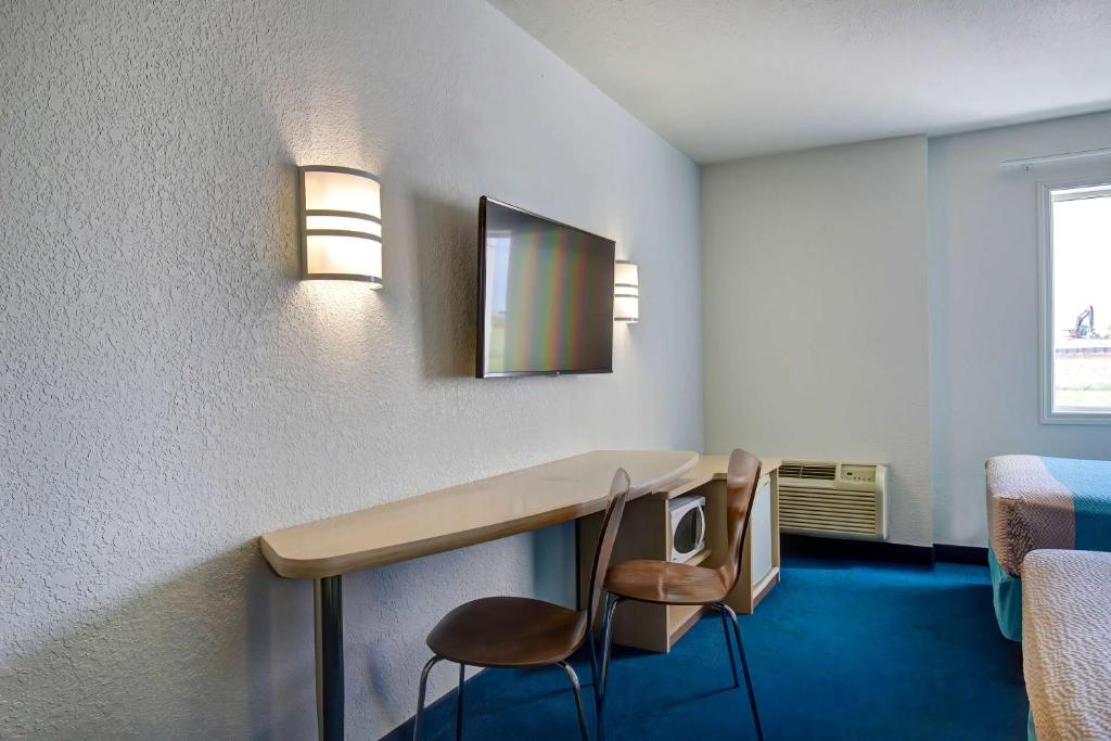 a room with a desk with a mirror and a chair at Motel 6-Grande Prairie, AB in Grande Prairie