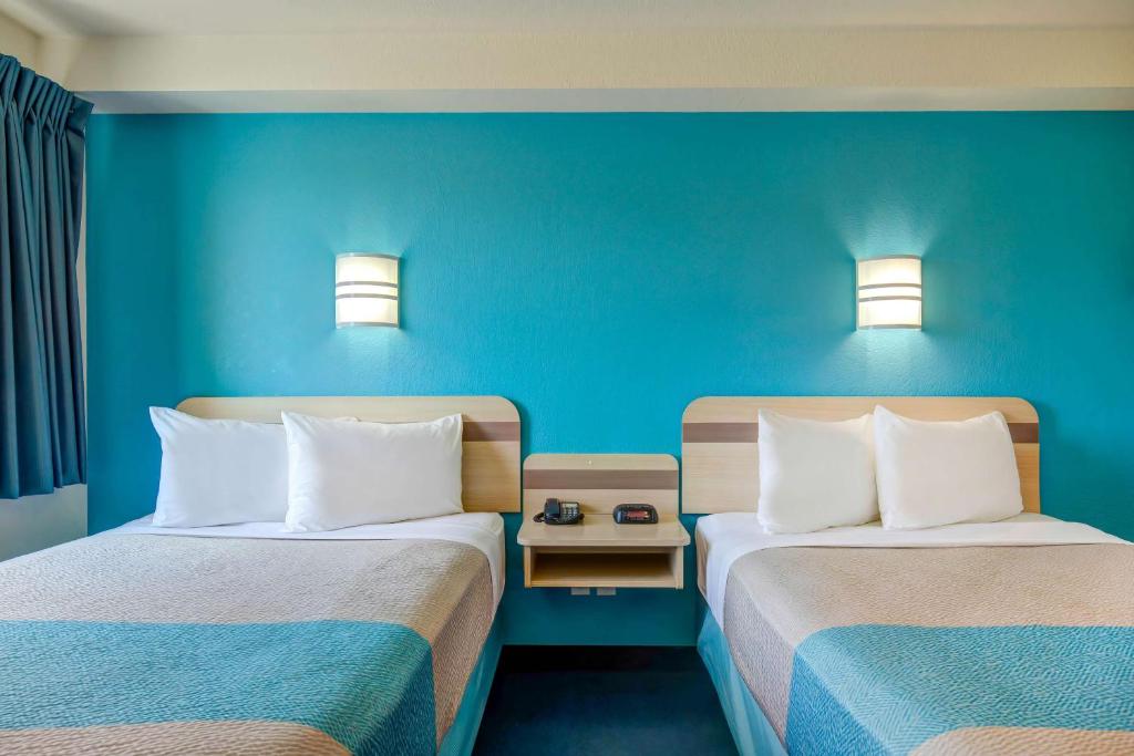 two beds in a room with blue walls at Motel 6-Grande Prairie, AB in Grande Prairie