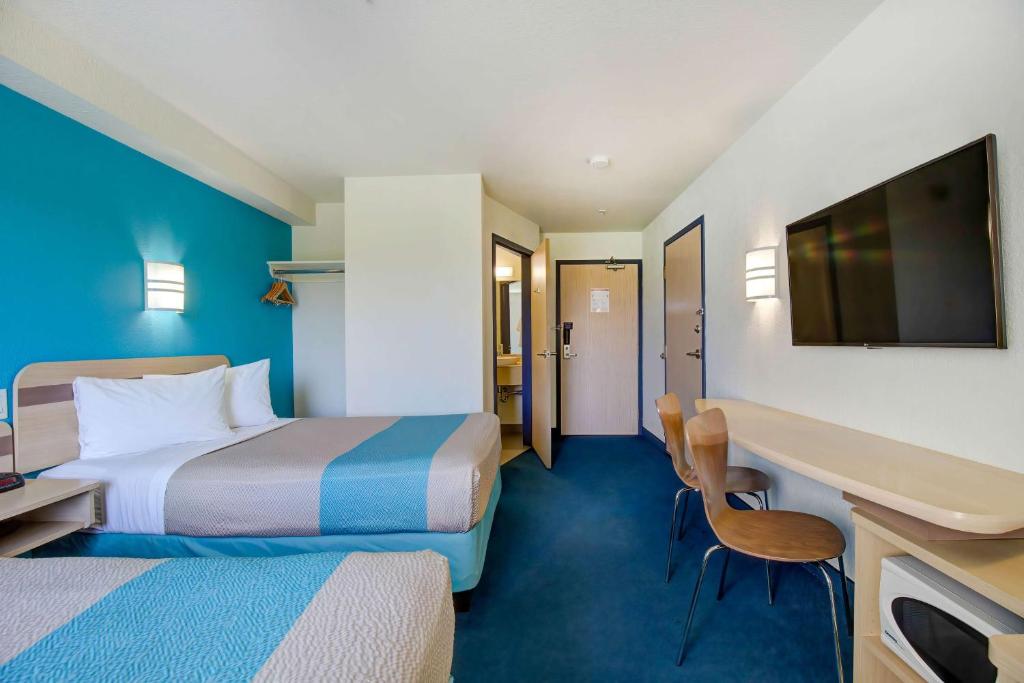 a hotel room with two beds and a flat screen tv at Motel 6-Grande Prairie, AB in Grande Prairie