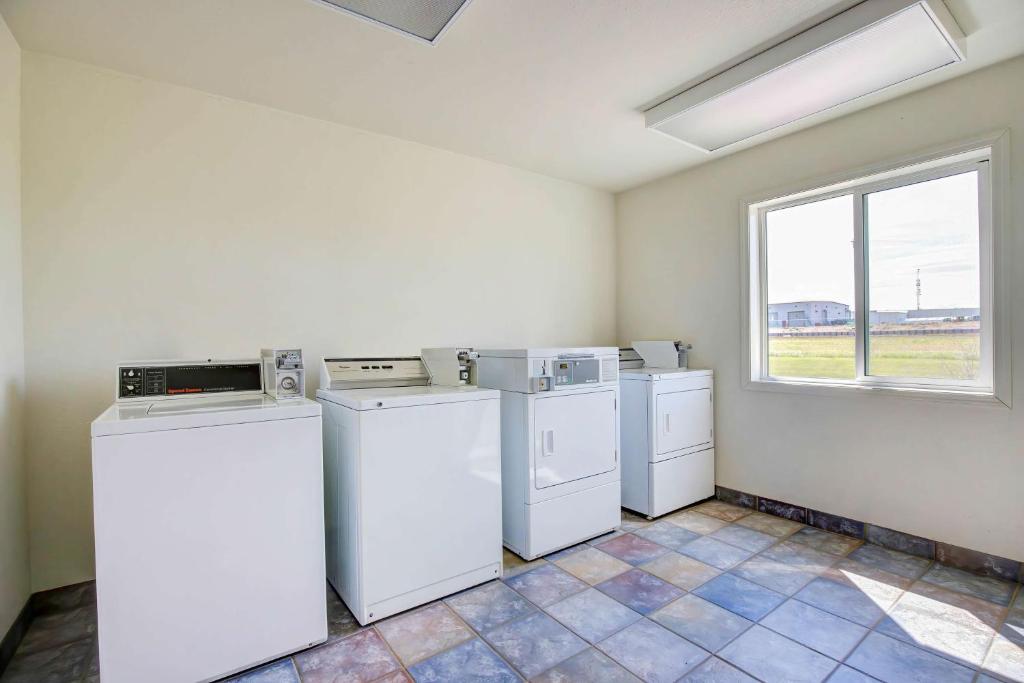 a laundry room with white appliances and a window at Motel 6-Grande Prairie, AB in Grande Prairie
