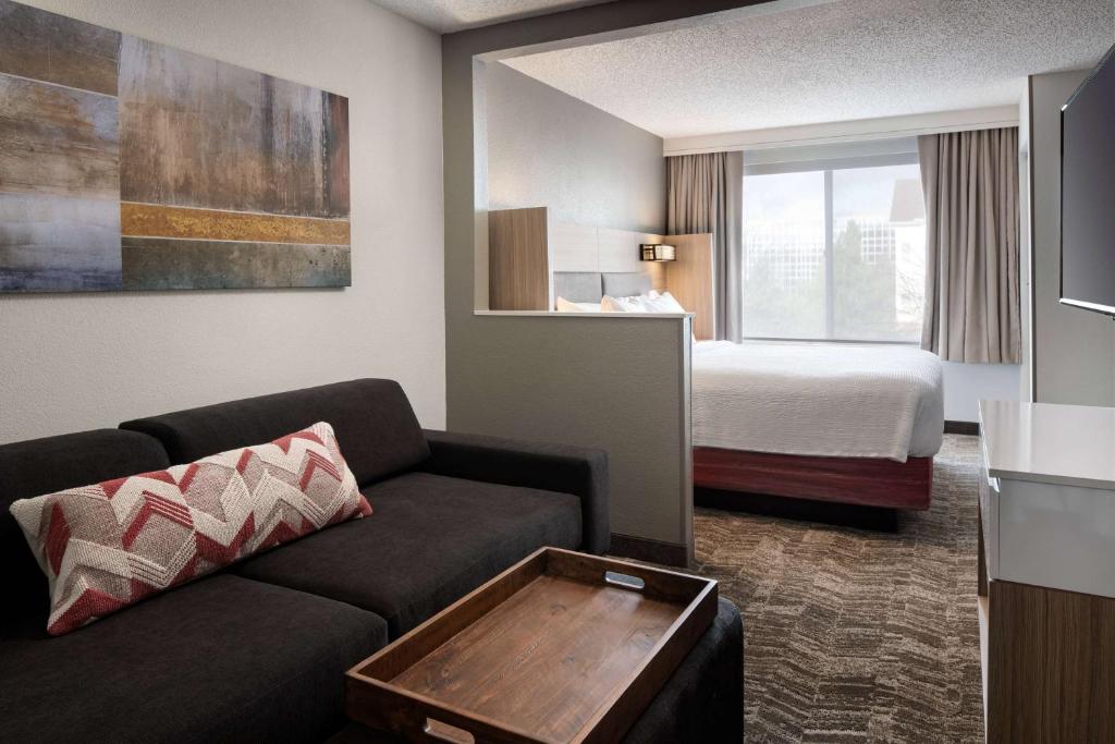Sonesta Select Seattle Renton Suites في رينتون: غرفة في الفندق مع أريكة وسرير