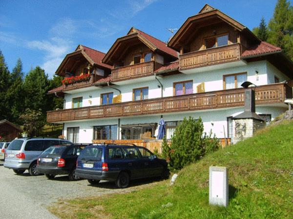 una casa grande con coches estacionados frente a ella en Ferienwohnungen Jagerhüttn, en Hochrindl