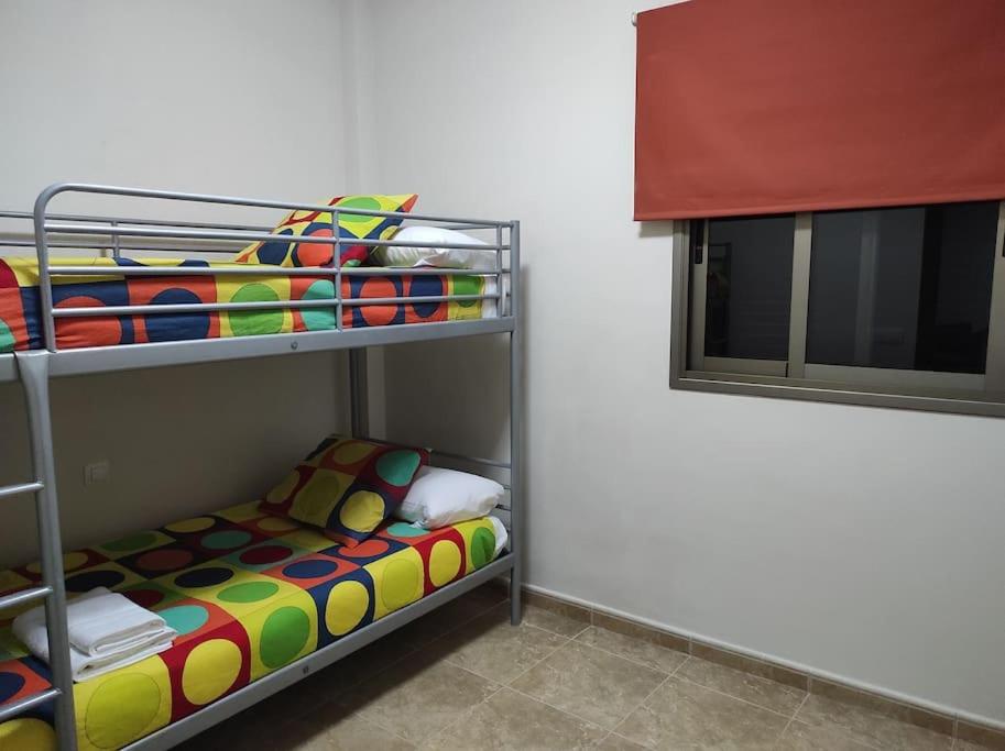 VV LA ISLA في لا ريستينجا: سرير بطابقين مع سرير ملون في الغرفة