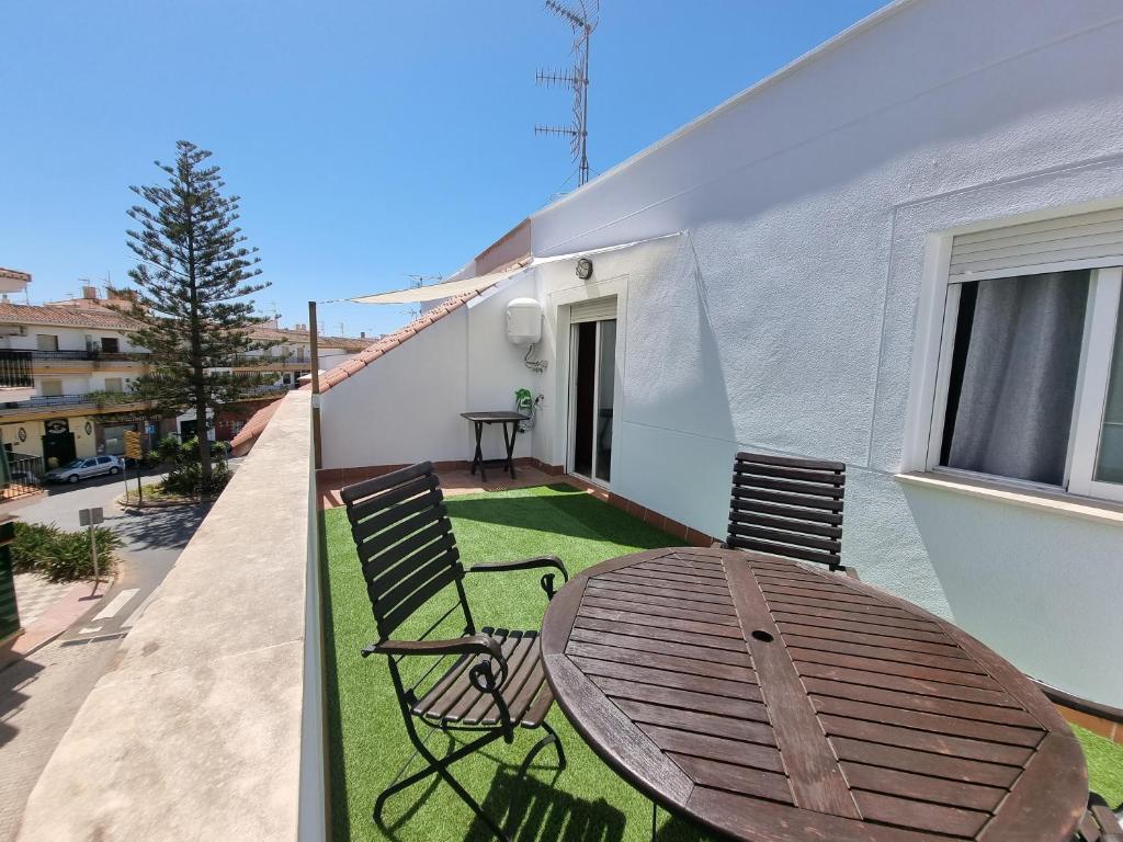 patio con mesa de madera y sillas en el balcón en 600m de la playa, terraza soleada, en Salobreña