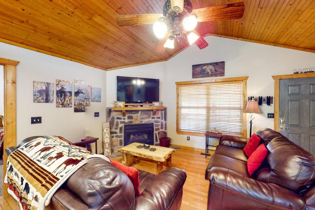 sala de estar con muebles de cuero y chimenea en Little Bear, en Branson