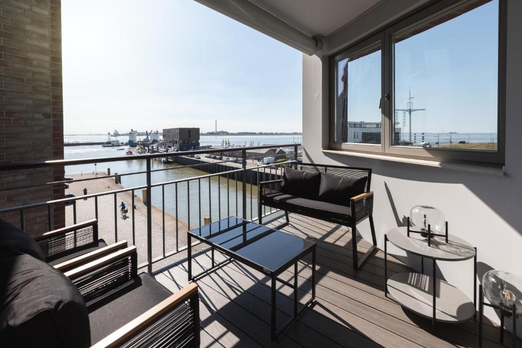 a room with a balcony with a view of the water at Bheaven I Sea Pilot Premium Apartment in Bremerhaven
