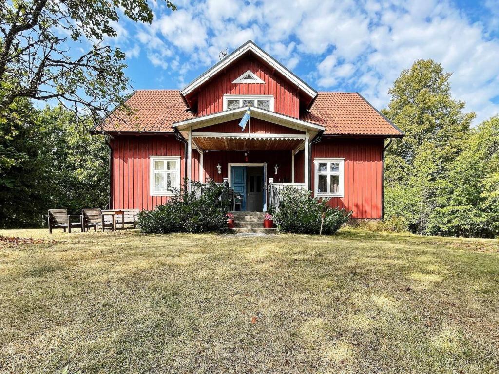una casa rossa con una panchina davanti di Holiday home ÖRSJÖ a Örsjö