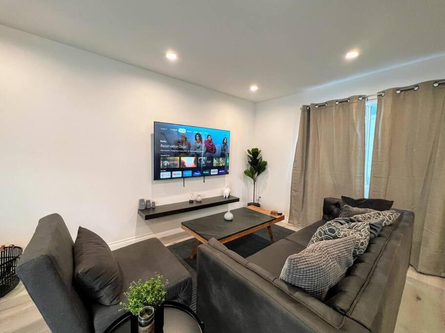 a living room with a couch and a flat screen tv at Hollywood Black Habitat in Los Angeles