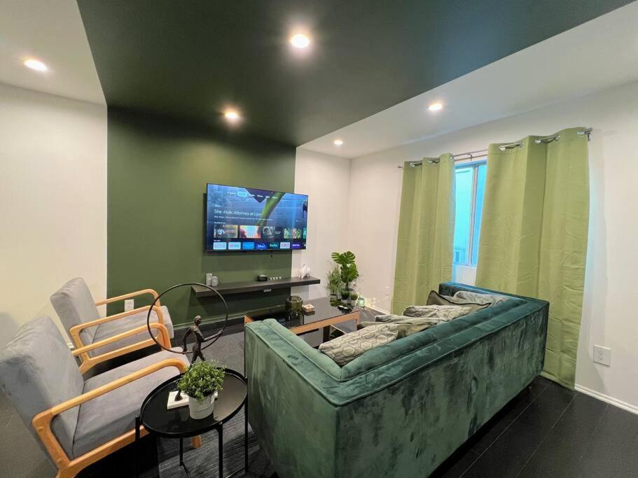 a living room with a green couch and a tv at Hollywood Green Habitat in Los Angeles