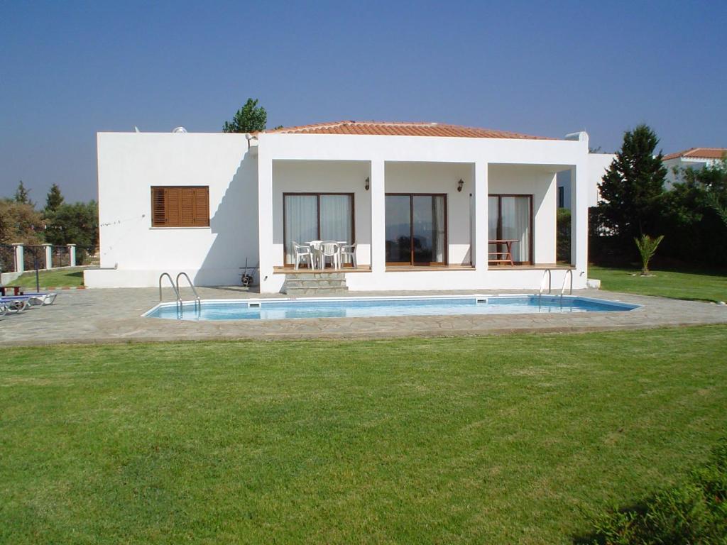 a white house with a swimming pool in the yard at Chriseleni Latchi Villas in Polis Chrysochous