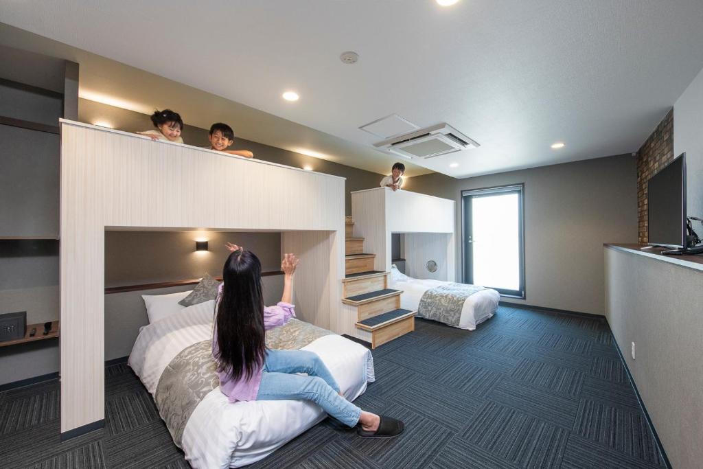 kobieta siedząca na łóżku w pokoju hotelowym w obiekcie ＥＮＴ　ＴＥＲＲＡＣＥ　ＡＳＡＫＵＳＡ w Tokio