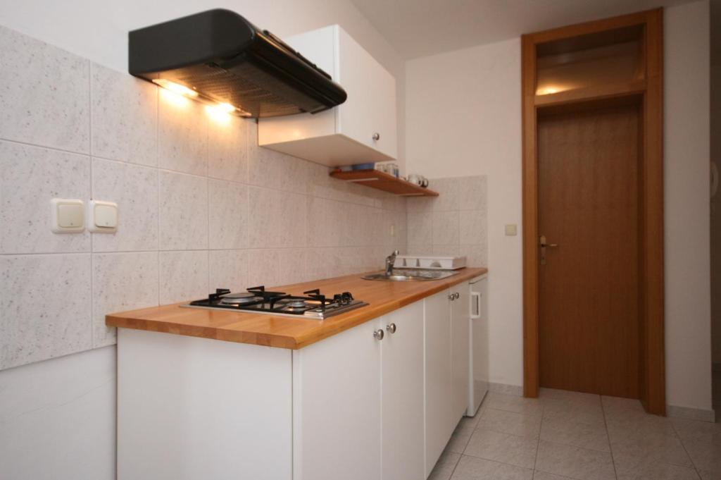 kuchnia z białymi szafkami i piekarnikiem w obiekcie Apartment Mandre 6405b w mieście Kolan