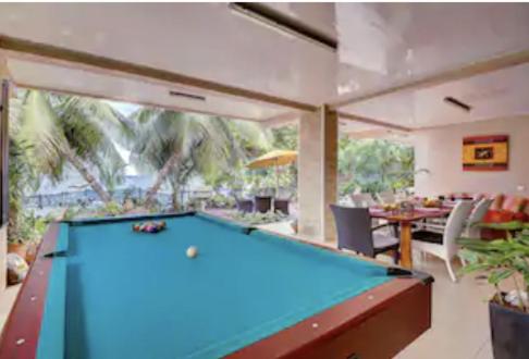 a pool table in a room with a dining room at Tahiti beach house in Arue