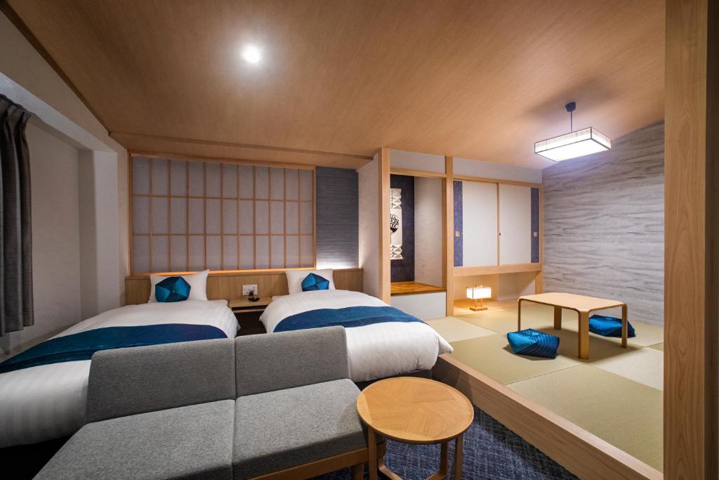 1 dormitorio con 2 camas y sofá en Rinn Niomon en Kyoto