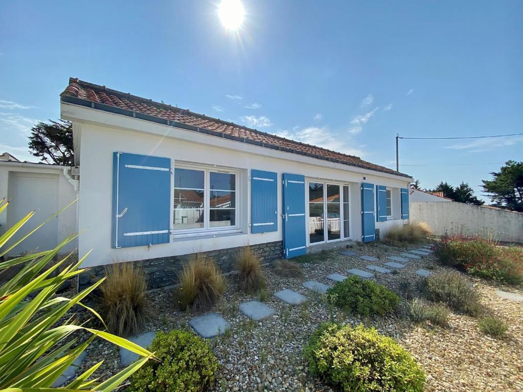 ein Haus mit blauen Türen und einem Hof in der Unterkunft Maison Bretignolles-sur-Mer, 5 pièces, 10 personnes - FR-1-231-76 in Brétignolles-sur-Mer