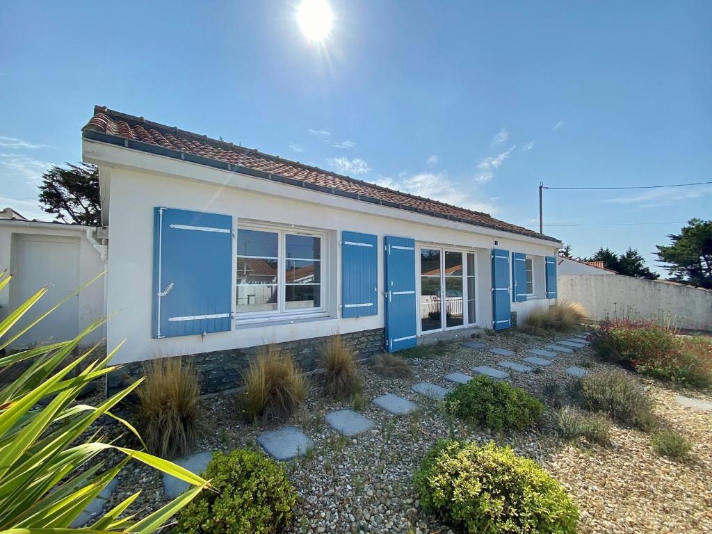 une maison avec des portes bleues et une cour dans l'établissement Maison rénovée tout confort - Proche plage, commerces et animations - WIFI inclus - FR-1-231-76, à Bretignolles-sur-Mer