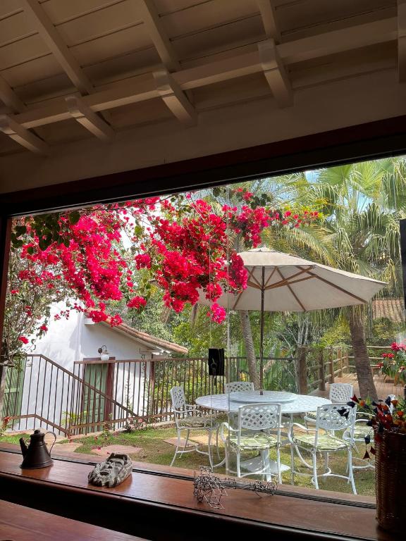 un patio con una mesa y una sombrilla en Pouso Jardim de Assis, en Ouro Preto
