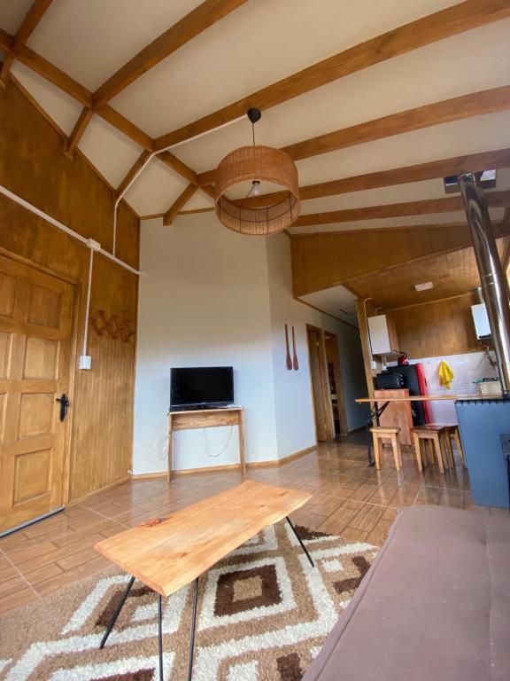 a living room with a wooden table and a couch at Siempre Verde in Puerto Tranquilo