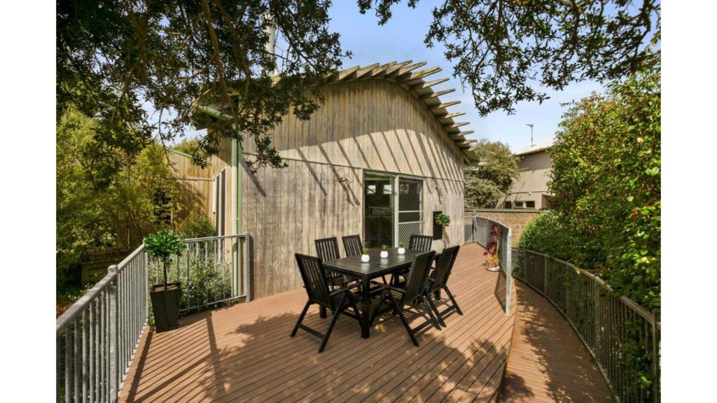 a wooden deck with a table and chairs on it at Surf Sounds in Inverloch