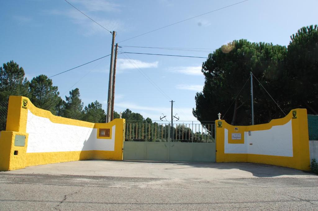 a yellow and white gate in a parking lot at Quinta A Reforma in Rossio ao Sul do Tejo