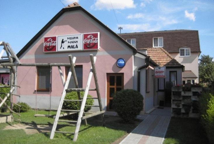 a pink house with a sign on the front of it at Penzion Mala in Jarovce