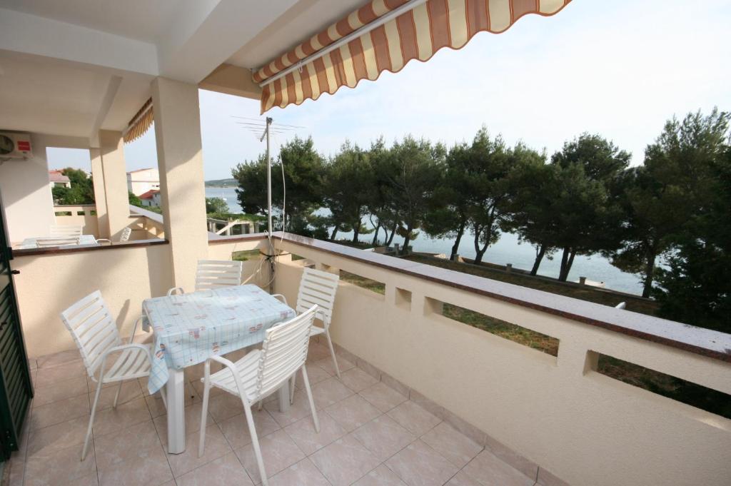 a table and chairs on a balcony with a view of the ocean at Apartment Stara Novalja 6375c in Novalja