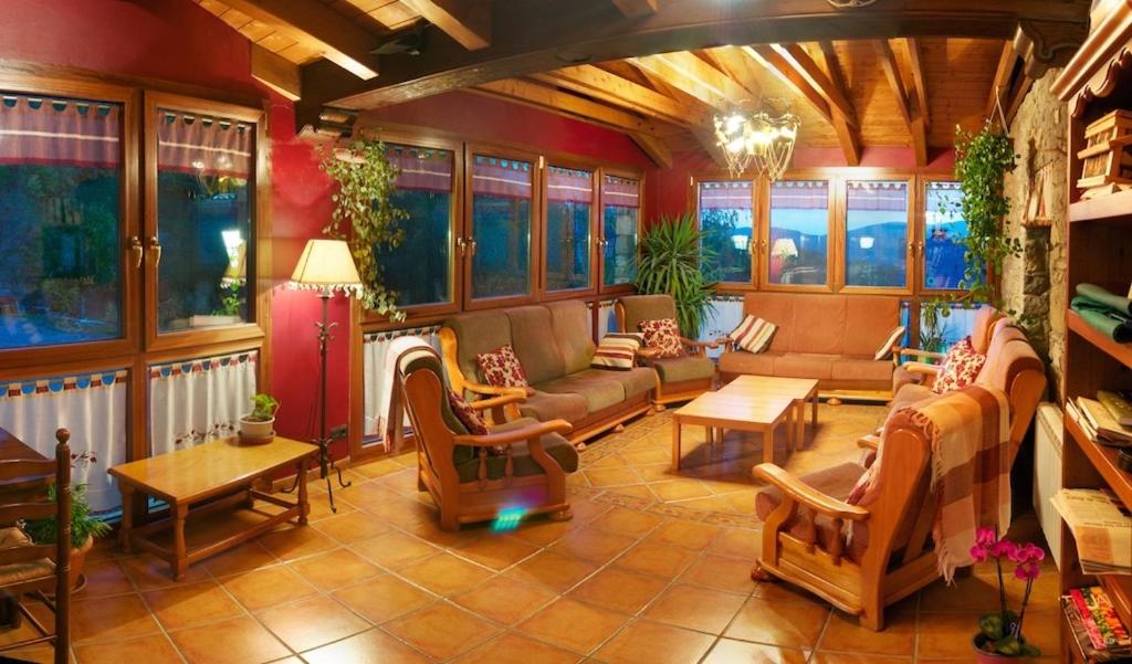 a living room filled with furniture and a fireplace at Hotel Ca de Graus in Castanesa