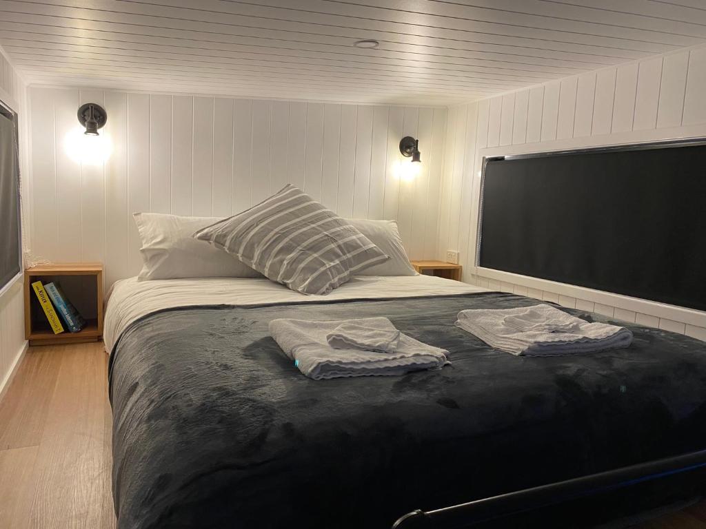 South Bruny的住宿－Adina Tiny House Bruny Island，一间卧室配有一张大床和两条毛巾