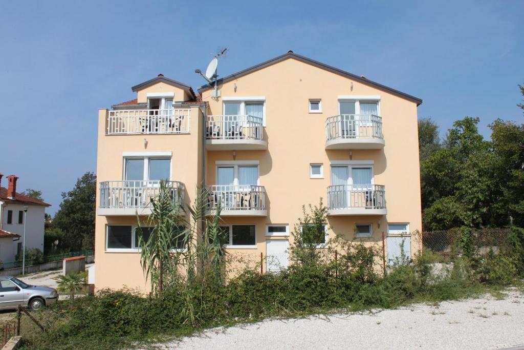 an apartment building with balconies on a beach at Apartments with a parking space Funtana, Porec - 7076 in Funtana