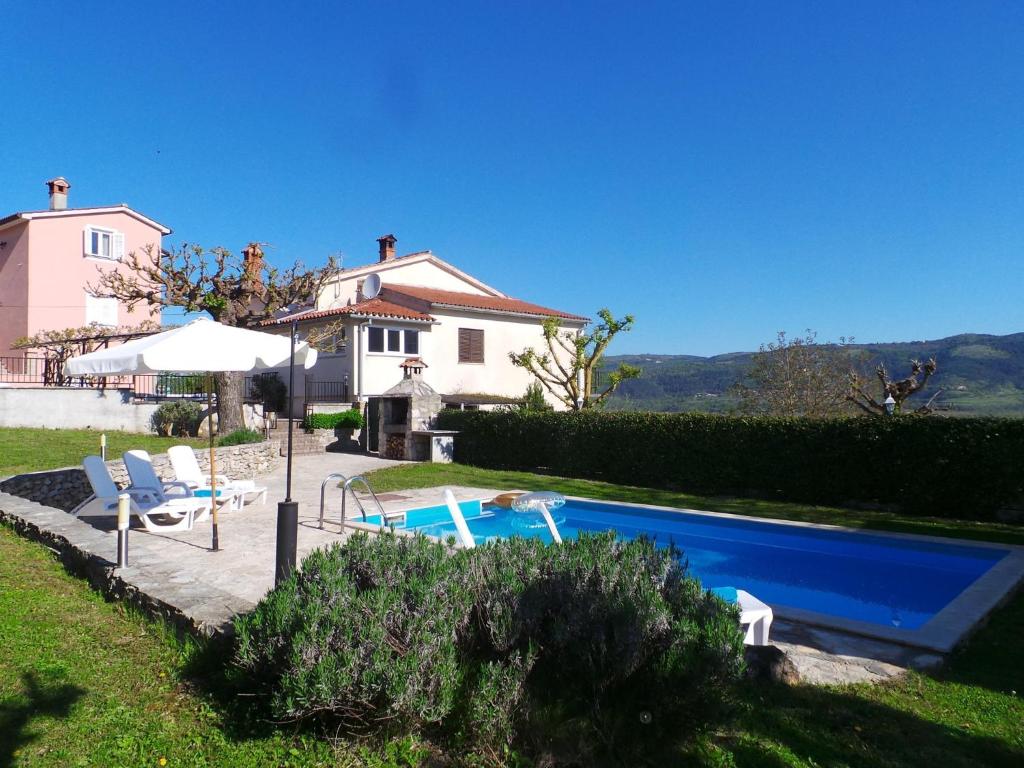 una casa con piscina frente a una casa en Apartments with a swimming pool Motovun - Bataji, Central Istria - Sredisnja Istra - 7069, en Motovun