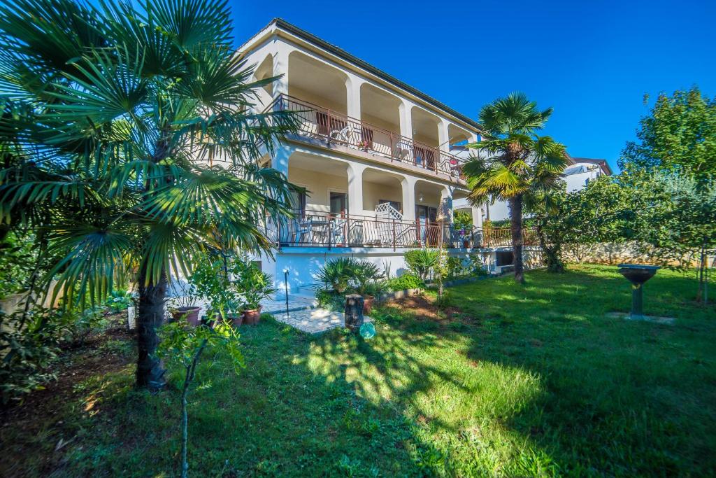 een groot huis met een palmboom ervoor bij Apartments with parking space Porec - 6984 in Poreč