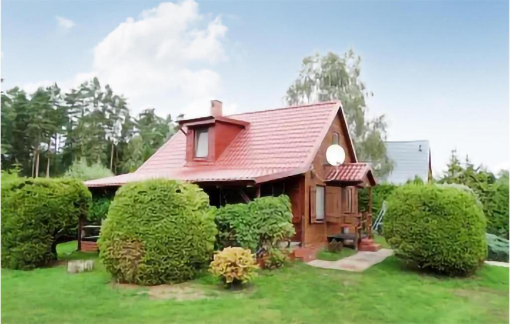 a small house with a red roof and some bushes at Amazing Home In Kopalino With 3 Bedrooms in Kopalino